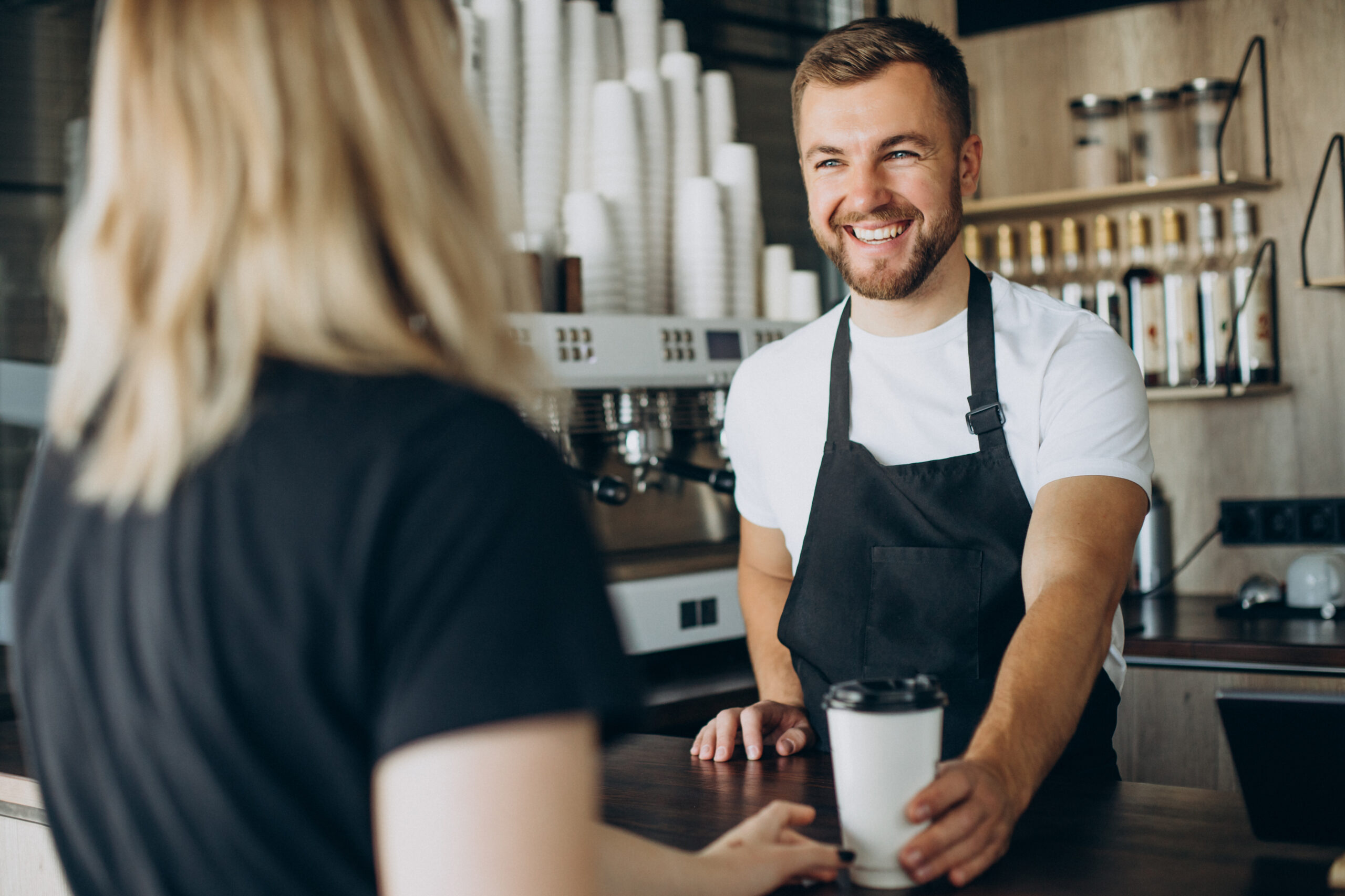 Pourquoi choisir Cafés T'heim pour votre concept café ? Barista servant un café à une cliente